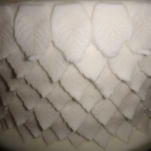 white leaf detail tier of wedding cake