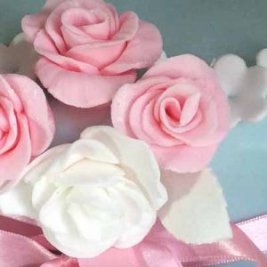 close up of pink and white roses on a baby blue cake
