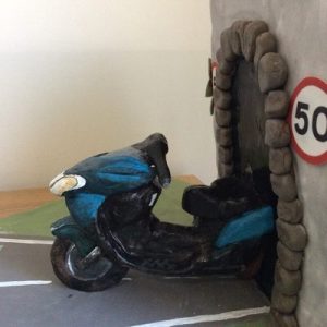 Tunnel effect cake with sculpted chocolate,blue bike coming out of the tunnel, finished with the words Yvonne born to ride, side view