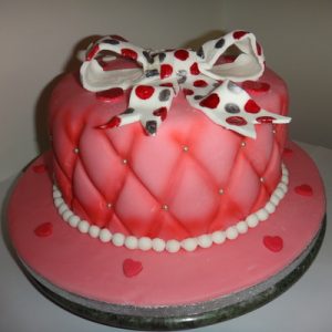 Pink quilted look cake with a giant white spotty bow on top