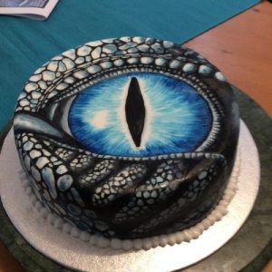 white cake hand painted with a blue dragons eye