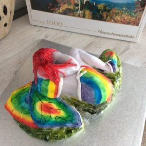 sculpted fairy cake lying curled up with hands over face,back view