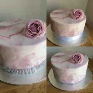 One tier Barrel cake with lilac marble icing and giant lilac flower presented in thee ways with different ribbons
